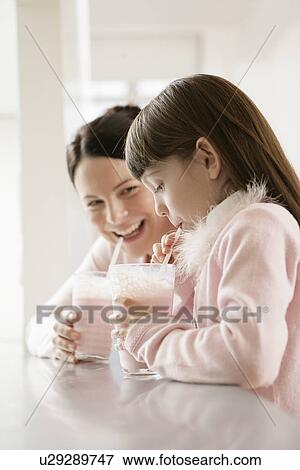 Stock Photo - Mother and daughter drinking smoothies. Fotosearch