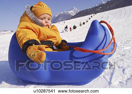 Stock Image - Little Baby in Weird Sled. Fotosearch