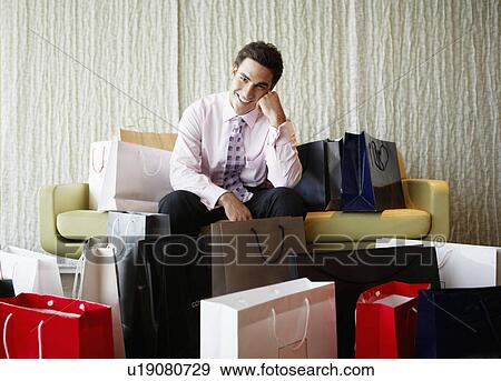 Businessman surrounded by shopping bags View Large Photo Image Stock Photo - Businessman surrounded by shopping bags. Fotosearch