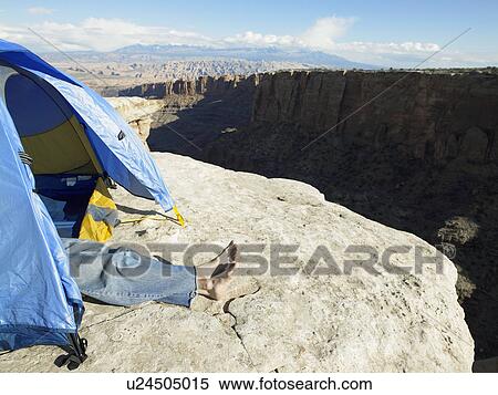 Stock Photography - Man sleeping in tent on cliff, Moab, Utah, USA. Fotosearch
