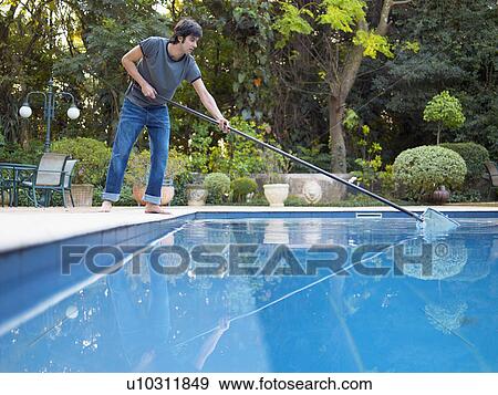 Stock Photo - Young man cleaning swimming pool (low angle view). Fotosearch