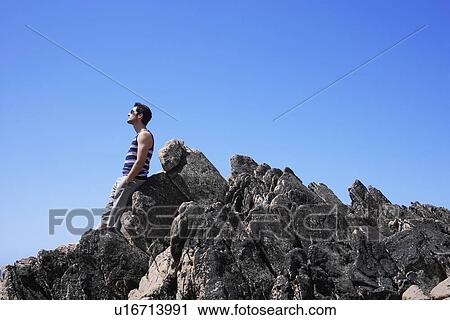 Young man leaning on rock View Large Photo Image Stock Image - Young man leaning on rock. Fotosearch