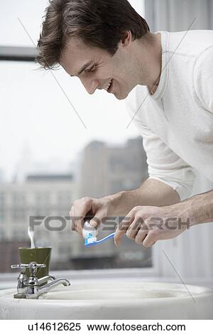Young man squeezing toothpaste out of tube View Large Photo Image Stock Photography - Young man squeezing toothpaste out of tube. Fotosearch