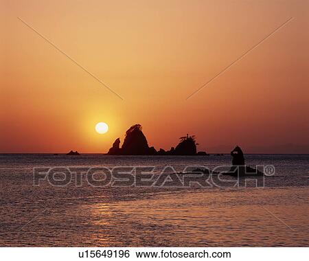 Stock Photograph - Sun Setting Behind Rocks. Fotosearch