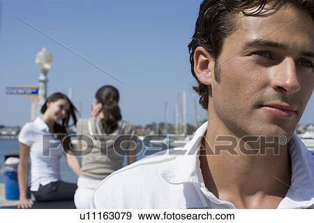 Stock Photo - Young adult man and women sitting behind, Front View, Side View, Rear View, Differential Focus. Fotosearch