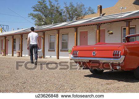 Stock Photo - Young man arriving at motel, Arizona, USA. Fotosearch