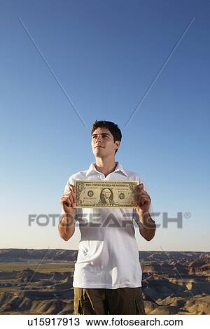 Stock Image - Young man holding large one dollar bill. Fotosearch