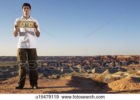 Young man holding large one dollar bill View Large Photo Image Stock Photo - Young man holding large one dollar bill. Fotosearch