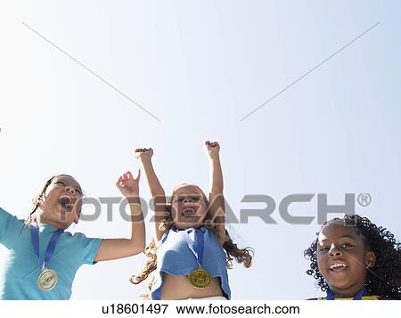 Girls celebrating medals (low angle view) View Large Photo Image Stock Photo - Girls celebrating medals (low angle view). Fotosearch