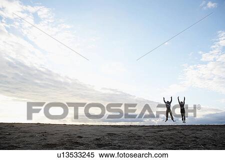 Man and woman jumping on beach View Large Photo Image Stock Photography - Man and woman jumping on beach. Fotosearch