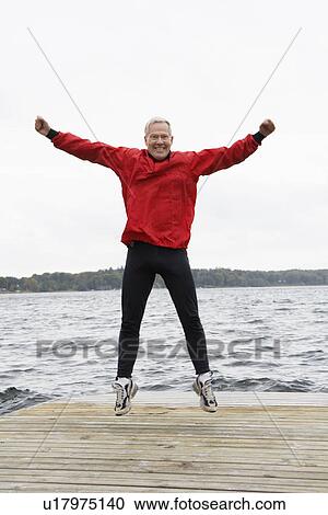 Senior man jumping on jetty View Large Photo Image Stock Image - Senior man jumping on jetty. Fotosearch