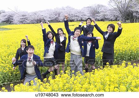 Stock Image - Students and New Business People Jumping In Rape Blossoms Field, Front View,. Fotosearch