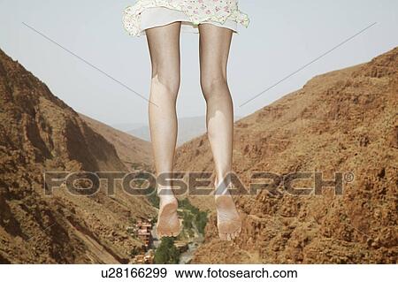 Stock Photo - Woman Jumping near Mountains. Fotosearch