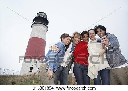 Five people photographing themselves by lighthouse (low angle view) View Large Photo Image Picture - Five people photographing themselves by lighthouse (low angle view). Fotosearch