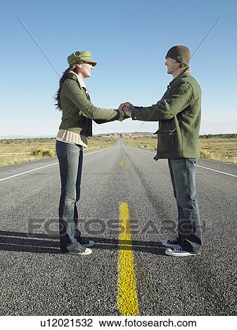Stock Image - Woman and man shaking hands on highway. Fotosearch