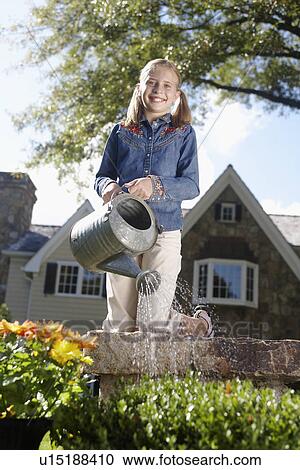 Girl (10-11) watering flowers, Chatham, New Jersey, USA View Large Photo Image Stock Image - Girl (10-11) watering flowers, Chatham, New Jersey, USA. Fotosearch