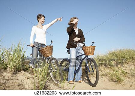 Couple with bicycles looking at view View Large Photo Image Stock Image - Couple with bicycles looking at view. Fotosearch