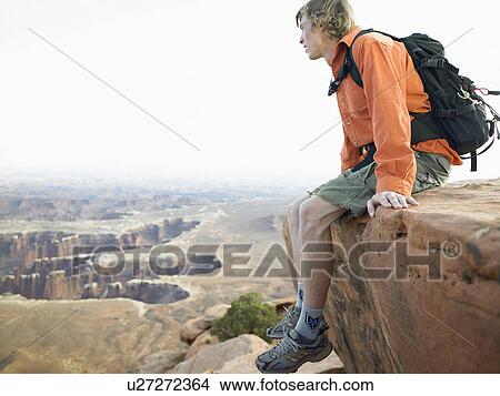 Male hiker sitting on cliff View Large Photo Image Picture - Male hiker sitting on cliff. Fotosearch