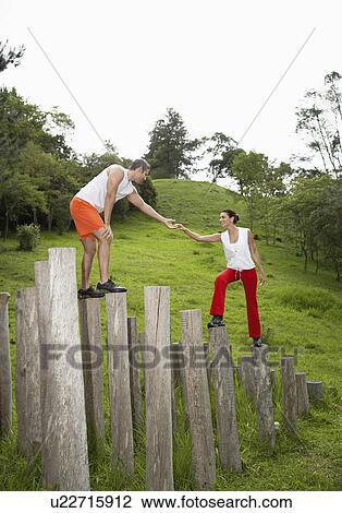 Man helping woman to climb tree stumps View Large Photo Image Stock Image - Man helping woman to climb tree stumps. Fotosearch
