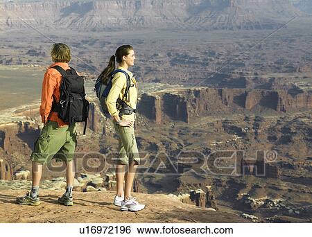 Two hikers looking at rock strata View Large Photo Image Stock Photograph - Two hikers looking at rock strata. Fotosearch