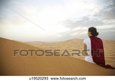Stock Image - Woman Looking at Mountains at Sunset. Fotosearch