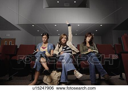 Stock Photograph - Three female students participating in lecture. Fotosearch