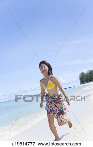 Portrait of a young woman running on beach, smiling, Saipan, USA View Large Photo Image Stock Photo - Portrait of a young woman running on beach, smiling, Saipan, USA . Fotosearch