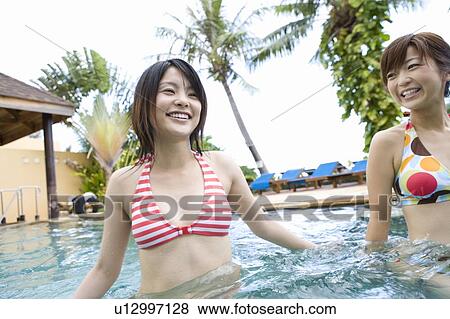 Stock Photo - Two women in bikini in swimming Pool, Saipan. Fotosearch