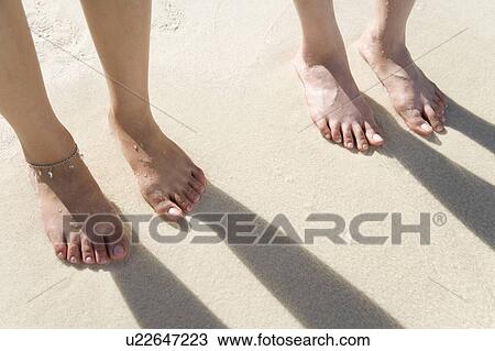 Stock Image - Two women standing on beach, Saipan, USA . Fotosearch