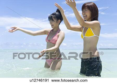 Two young women playing in the sea, smiling, Saipan, USA View Large Photo Image Stock Image - Two young women playing in the sea, smiling, Saipan, USA . Fotosearch
