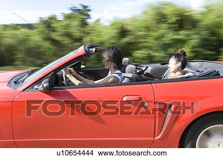Young man and woman in the car, man driving, panning, Saipan, USA View Large Photo Image Picture - Young man and woman in the car, man driving, panning, Saipan, USA . Fotosearch