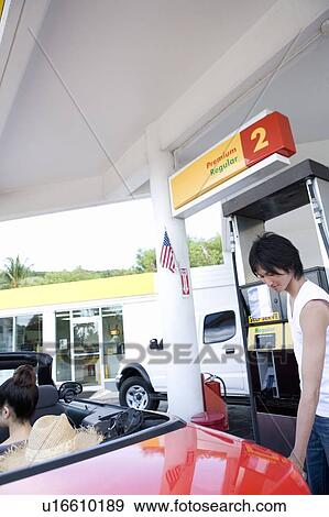 Stock Photo - Young man filling car in gas station, Saipan, USA . Fotosearch