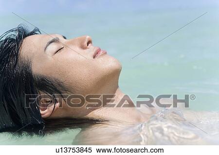 Stock Photography - Young man in the sea, closing eyes, Saipan, USA . Fotosearch
