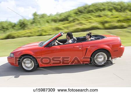Stock Photo - Young people in the car, man driving, panning, Saipan, USA . Fotosearch