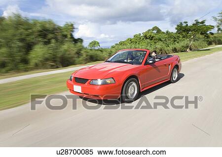 Stock Photography - Young people in the car, man driving, panning, Saipan, USA . Fotosearch