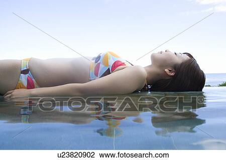 Young woman in a bikini lying on water, Saipan View Large Photo Image Stock Image - Young woman in a bikini lying on water, Saipan. Fotosearch