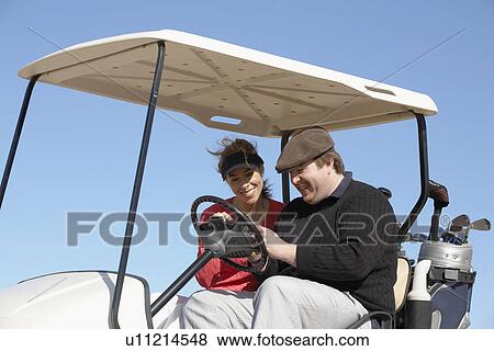 Woman and man text messaging in golf cart View Large Photo Image Stock Photo - Woman and man text messaging in golf cart. Fotosearch