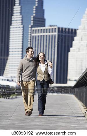 Stock Image - Couple walking on bridge, New York City, New York, USA. Fotosearch