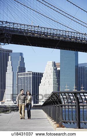 Couple walking under Brooklyn Bridge, New York City, New York, USA View Large Photo Image Stock Photo - Couple walking under Brooklyn Bridge, New York City, New York, USA. Fotosearch