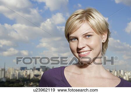 Stock Photo - Portrait of blond woman, city in background, Sao Paulo, Brazil. Fotosearch