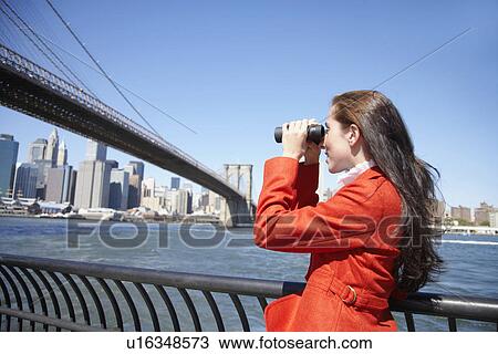Woman using binoculars near Brooklyn Bridge, New York City, New York, USA View Large Photo Image Stock Image - Woman using binoculars near Brooklyn Bridge, New York City, New York, USA. Fotosearch