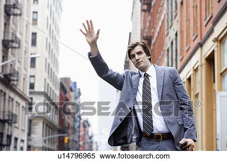 Young businessman hailing taxi cab View Large Photo Image Stock Photography - Young businessman hailing taxi cab. Fotosearch