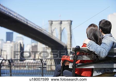 Stock Photo - Young couple looking at Brooklyn Bridge (rear view), New York City, New York, USA. Fotosearch