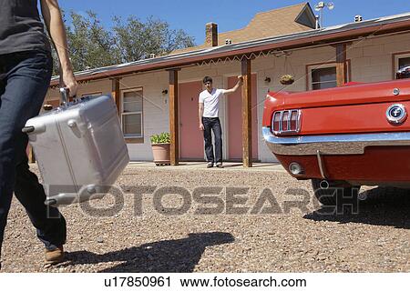 Boyfriend looking at girlfriend leaving with suitcase View Large Photo Image Stock Image - Boyfriend looking at girlfriend leaving with suitcase. Fotosearch