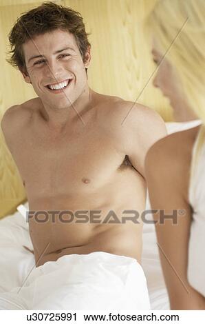 Young couple on bed View Large Photo Image Stock Image - Young couple on bed. Fotosearch