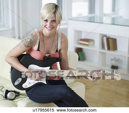 Stock Photography - Young Woman Playing Electric Guitar. Fotosearch