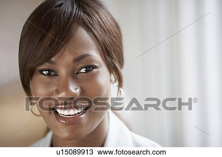 Stock Image - Young woman smiling (portrait). Fotosearch