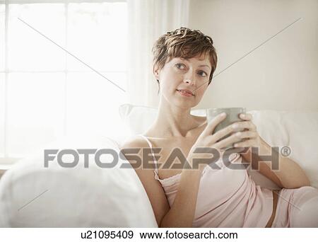 Stock Photo - Mid adult woman drinking coffee. Fotosearch