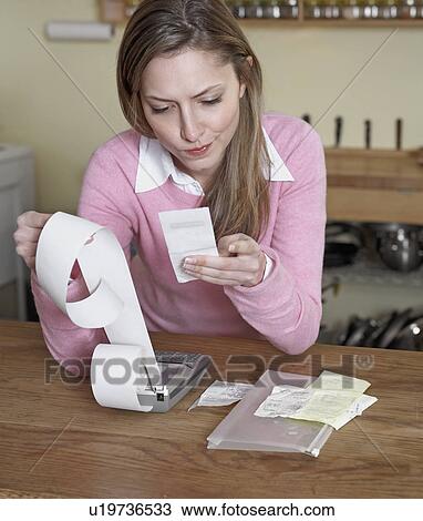 Stock Image - Mid-Adult Woman Examining Receipts. Fotosearch