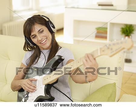 Stock Photo - Mid-Adult Woman Playing Electric Guitar. Fotosearch